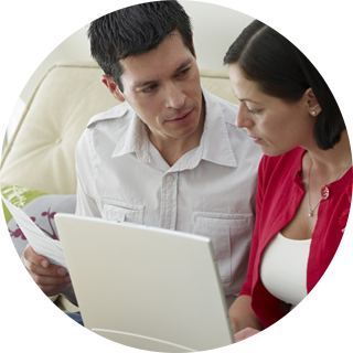 Couple looking at laptop while planning to buy their first home